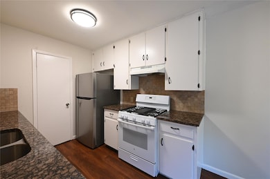 Kitchen featuring white gas stove, under cabinet 