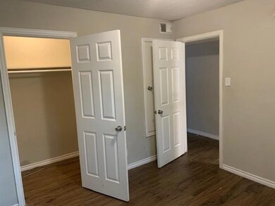 Unfurnished bedroom featuring dark wood-style floo