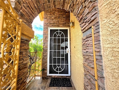 Doorway to property featuring a gate, stone siding