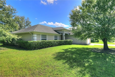 View of front of home featuring stucco siding, a garage, a front lawn, and driveway