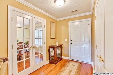 The foyer has hardwood floors, double door coat closet and french doors leading to the dining room.