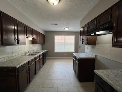 Kitchen with a textured ceiling, dark brown cabine