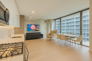 Kitchen with stainless steel appliances, expansive windows, white cabinets, modern cabinets, and recessed lighting