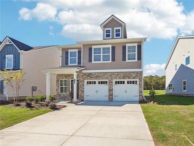 View of front facade with driveway, an attached garage, a front yard, and brick siding