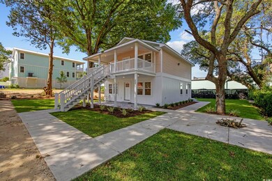 View of front of home with a front yard, a balcony, stairs, and a porch