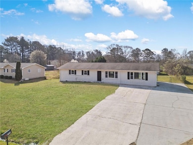 Ranch-style home with a front lawn, board and batt