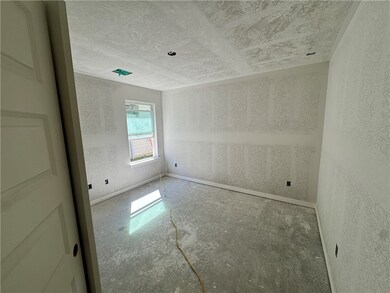 Empty room with a textured ceiling and concrete flooring