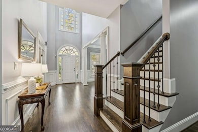 Soaring two-story foyer with abundant natural light, elegant millwork, and a beautifully updated staircase.