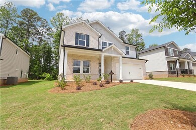 Craftsman inspired home featuring board and batten siding, brick siding, driveway, and an attached garage