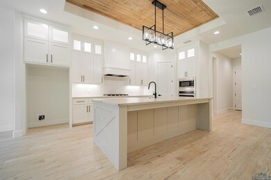 Kitchen featuring a center island with sink, appli