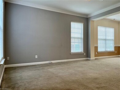 Large living room with ceiling fan/light, two windows, coat closet, crown molding.