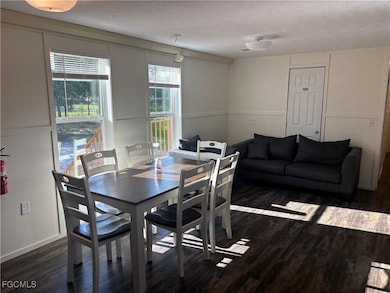 Dining room featuring a textured ceiling and dark wood-style flooring