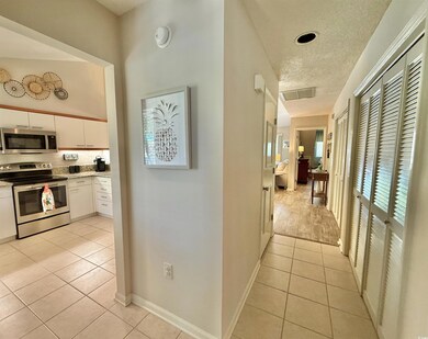 Hallway with light tile patterned flooring, a text