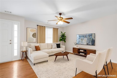 Living room with light wood-style flooring and ceiling fan