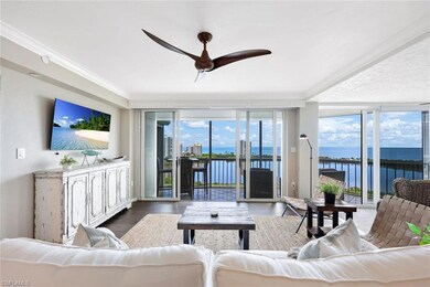 Living room featuring a water view, ceiling fan, e