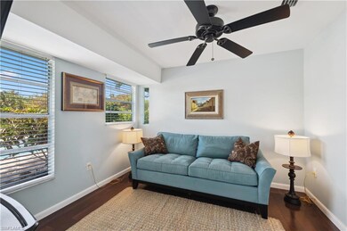Living room featuring ceiling fan and dark hardwoo