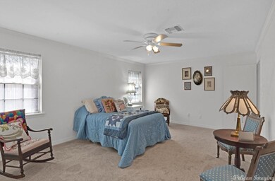 Carpeted bedroom featuring ceiling fan and crown m