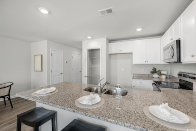 Kitchen with white cabinetry, sink, a kitchen brea