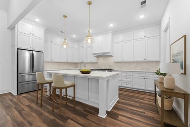 This gourmet kitchen is designed to impress with quartz counters, abundant cabinetry, stainless appliances, gas cooking, tile details, breakfast bar, and pantry.