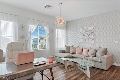 Living room with wallpapered walls, a chandelier,
