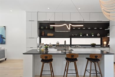 Kitchen with modern cabinets, dark countertops, w