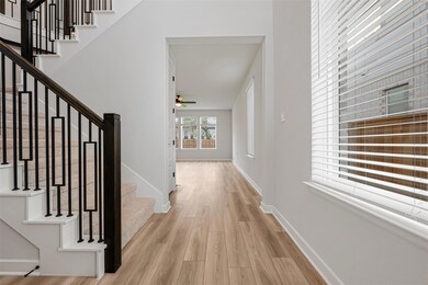 Hall with wood finished floors, stairs, and baseb