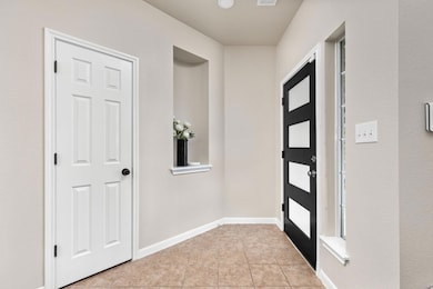 Entrance foyer with light tile patterned flooring