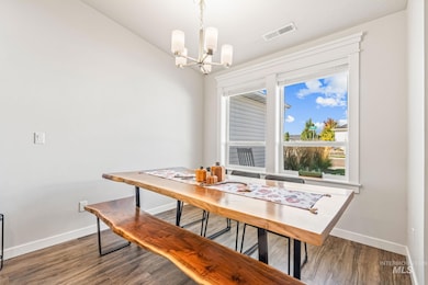 Dining area with wood finished floors and a chandelier