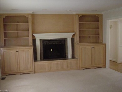 Living room has built-ins around beautiful fireplace with gas logs.