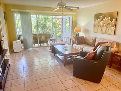 Living room featuring ceiling fan and light tile p