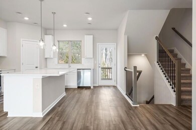 Kitchen featuring dark wood-style floors, white cabinets, dishwasher, light countertops, and decorative backsplash