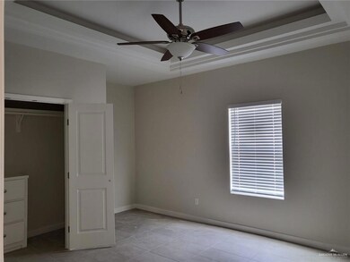 Unfurnished bedroom featuring a tray ceiling, baseboards, and multiple windows
