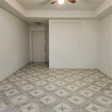 Spare room featuring a ceiling fan and baseboards