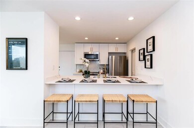 Kitchen with white cabinetry, a breakfast bar, app