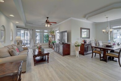 Living room with a ceiling fan, healthy amount of natural light, light wood-style flooring, and crown molding