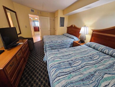 Carpeted bedroom with a closet and electric panel