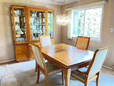 Dining area with a chandelier, carpet floors, crown molding, and baseboards