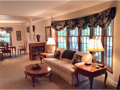 Living room features bay window & built in bookcas