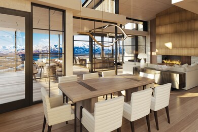 Dining space featuring a warm lit fireplace, a chandelier, wood finished floors, expansive windows, and a towering ceiling