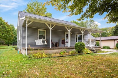 View of front of house with a large front porch with 2 swings and a large front yard