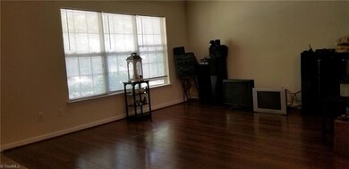 The living room features wood laminate flooring and the triple window which lets in the light.