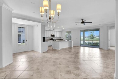 Kitchen with a center island with sink, white cabinets, ornamental molding, and light tile floors
