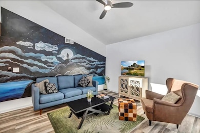 Living room with ceiling fan, lofted ceiling, woo