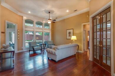 This Living Area Overlooks the Pool and Patio and Boasts Hardwood Flooring, Elegant Mouldings and Arched Windows.