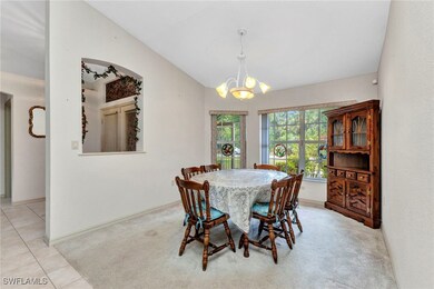 Carpeted dining area with a chandelier, lofted cei