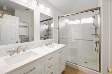 Full bath with a stall shower, double vanity, and