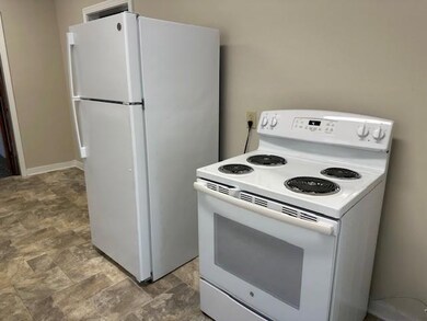 Kitchen featuring white appliances and stone finish floors
