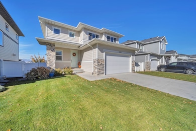View of front of house with stone siding, concrete driveway, and an attached garage