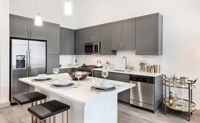 Model has a has abundant cabinet space ,side by side refrigerator,  a dining island which frees up space in the living area with pendant lighting