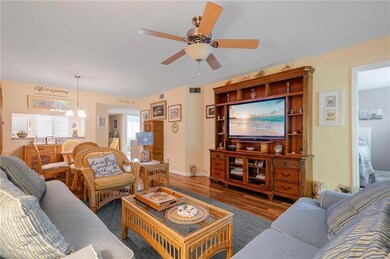 Living room featuring ceiling fan and dark hardwoo